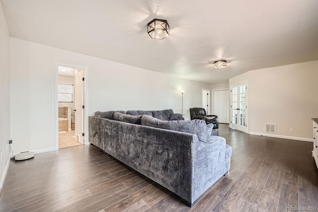 living room with a textured ceiling and dark wood-type flooring