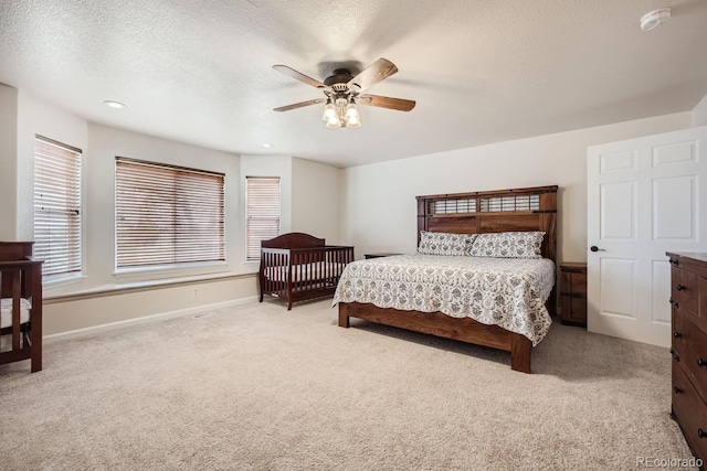 carpeted bedroom with a textured ceiling and ceiling fan