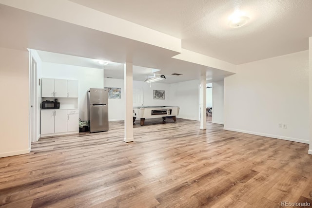 unfurnished living room with a textured ceiling, light hardwood / wood-style flooring, and billiards