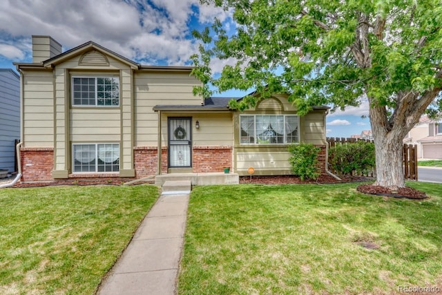 4302 Nepal St, Denver, CO 80249 - split level home with brick siding, a front lawn, and a chimney
