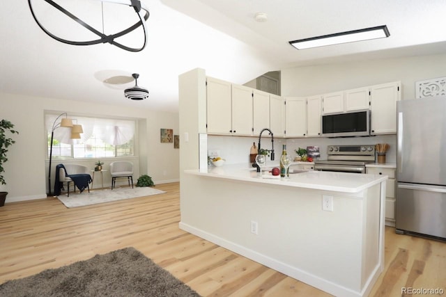 4302 Nepal St, Denver, CO 80249 - kitchen with stainless steel appliances, lofted ceiling, light wood finished floors, light countertops, and baseboards