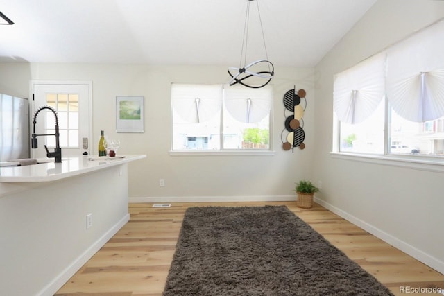 4302 Nepal St, Denver, CO 80249 - kitchen featuring healthy amount of natural light, light wood-style floors, a chandelier, and baseboards