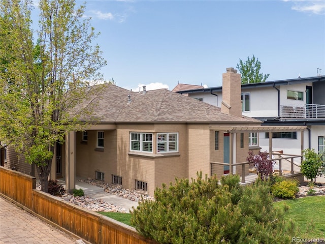 4425 Irving St, Denver, CO 80211 - rear view of property featuring a chimney, brick siding, roof with shingles, and fence