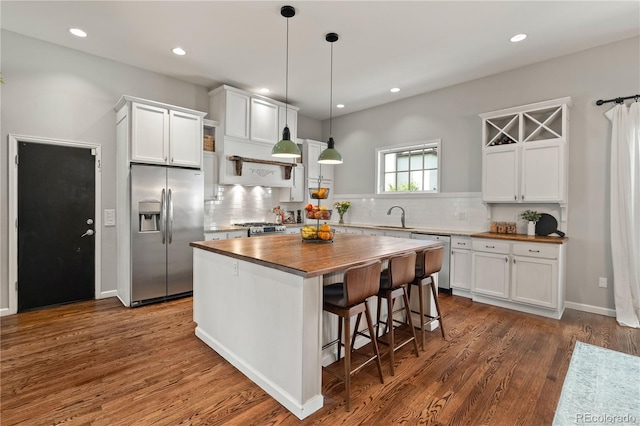 4425 Irving St, Denver, CO 80211 - kitchen featuring stainless steel appliances, wooden counters, a sink, white cabinets, and a center island