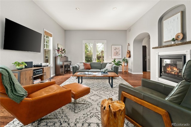 4425 Irving St, Denver, CO 80211 - living room featuring arched walkways, wood finished floors, a glass covered fireplace, baseboards, and recessed lighting