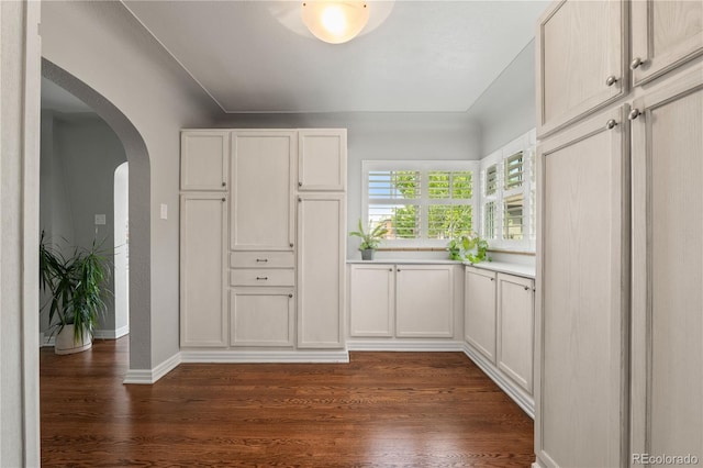 4425 Irving St, Denver, CO 80211 - kitchen featuring arched walkways, dark wood finished floors, white cabinets, and light countertops