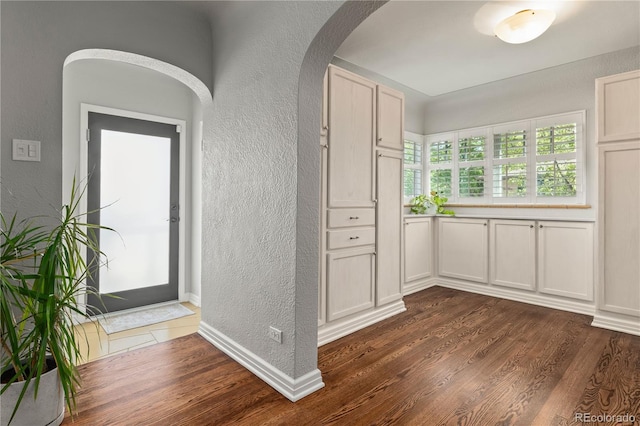 4425 Irving St, Denver, CO 80211 - interior space featuring a textured wall, arched walkways, dark wood finished floors, light countertops, and baseboards