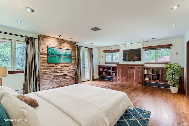 bedroom featuring baseboard heating and wood-type flooring