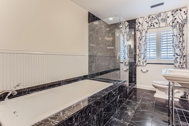 bathroom featuring toilet and separate shower and tub