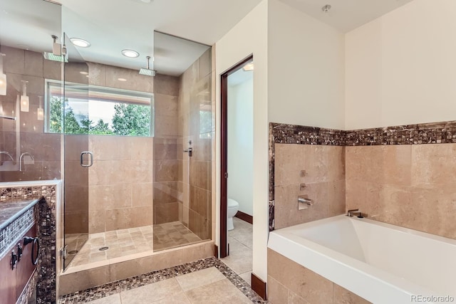 bathroom featuring tile patterned floors, toilet, tile walls, and separate shower and tub