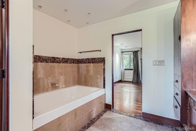 bathroom with a bathing tub and tile patterned flooring