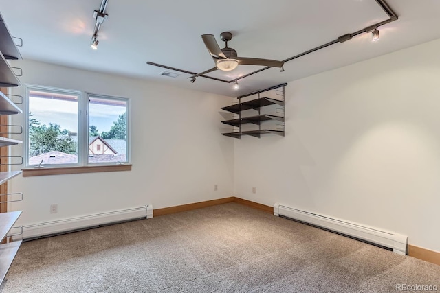 carpeted spare room with ceiling fan, rail lighting, and a baseboard heating unit