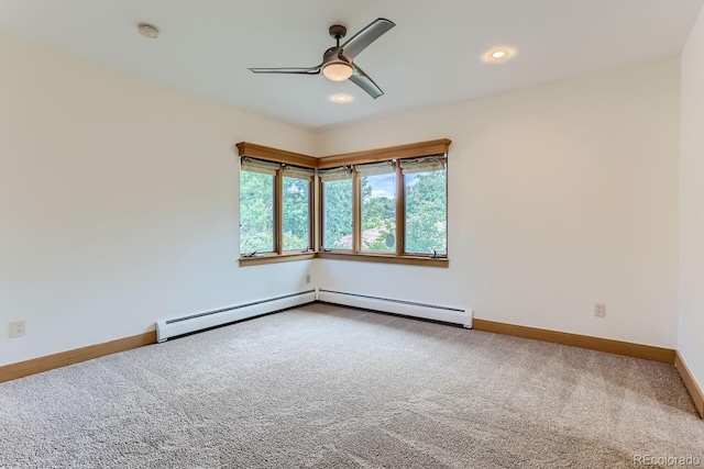 carpeted spare room with ceiling fan and a baseboard heating unit