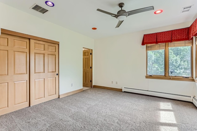 unfurnished bedroom featuring carpet floors, baseboard heating, a closet, and ceiling fan