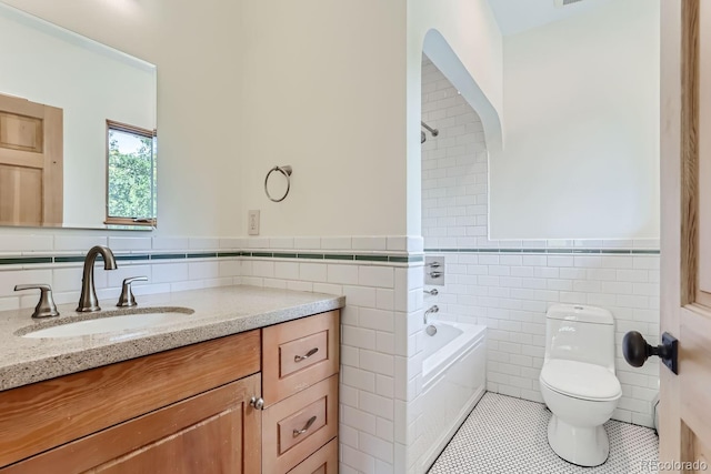 bathroom with tile patterned flooring, vanity, tile walls, toilet, and a bathing tub