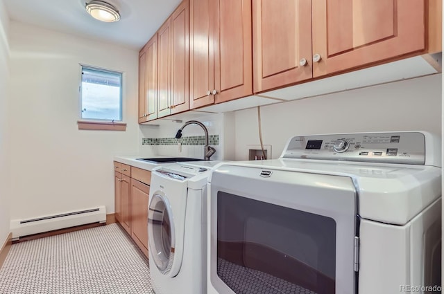 clothes washing area featuring independent washer and dryer, a baseboard heating unit, sink, and cabinets