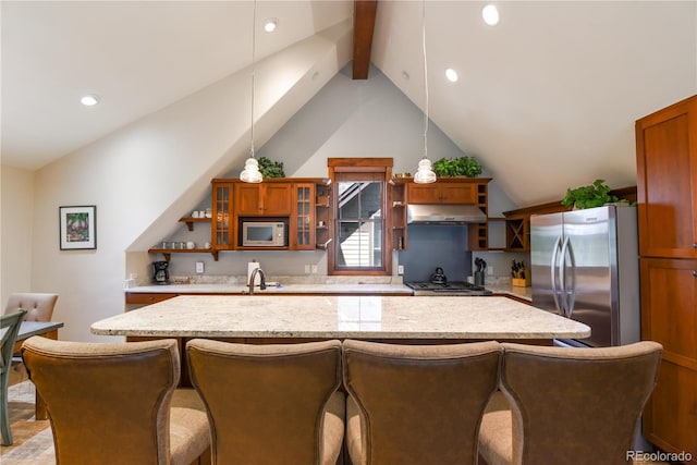 302 N Main St, Breckenridge, CO 80424 - kitchen featuring appliances with stainless steel finishes, under cabinet range hood, brown cabinets, a center island, and a breakfast bar