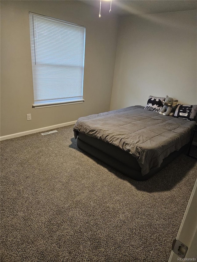 bedroom with baseboards and carpet