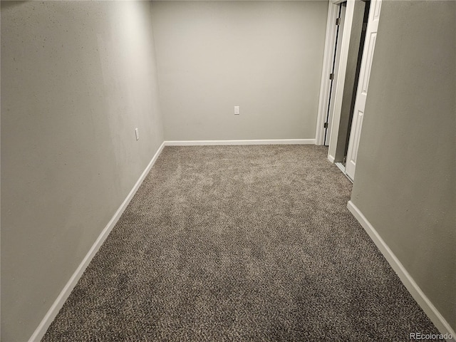 carpeted empty room featuring baseboards