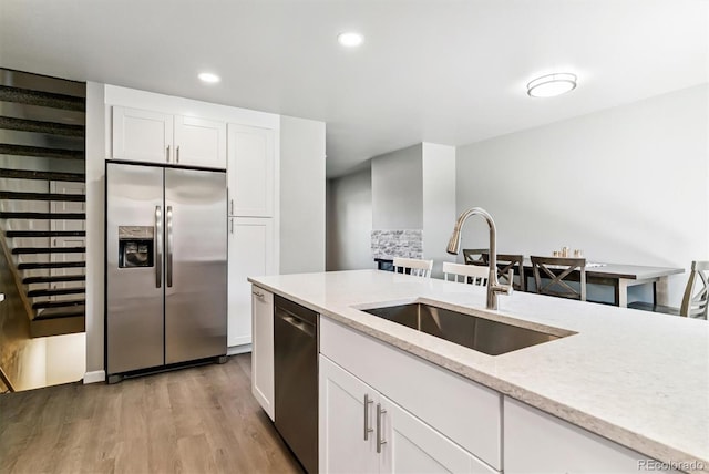 1927 S Peoria St, Aurora, CO 80014 - kitchen featuring stainless steel appliances, light wood-style flooring, white cabinetry, light stone counters, and recessed lighting