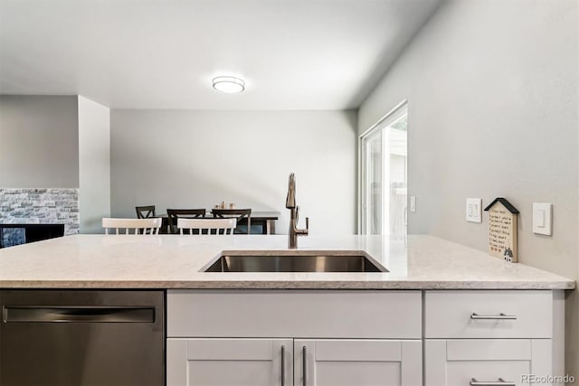 1927 S Peoria St, Aurora, CO 80014 - kitchen featuring stainless steel dishwasher, white cabinetry, and light stone countertops