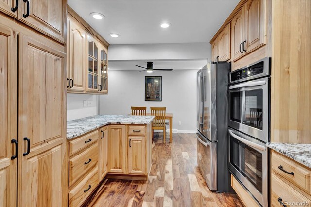 13624 Omega Cir, Lone Tree, CO 80124 - kitchen with appliances with stainless steel finishes, light brown cabinets, light wood finished floors, glass insert cabinets, and recessed lighting