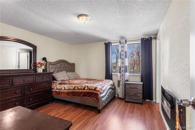 bedroom featuring a textured ceiling and hardwood / wood-style flooring