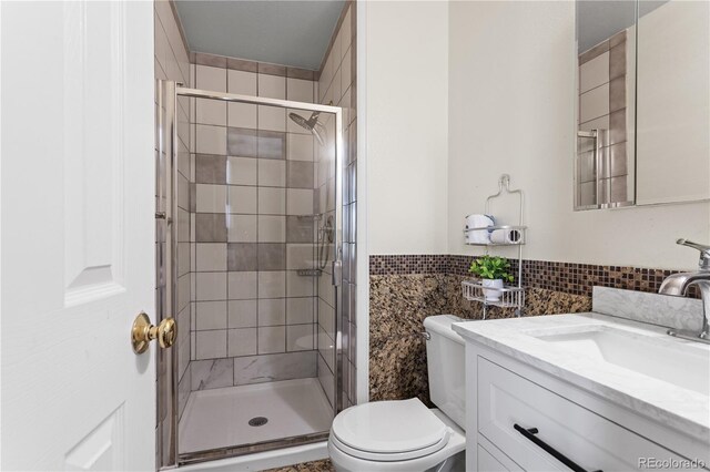 bathroom with vanity, toilet, and a shower with door