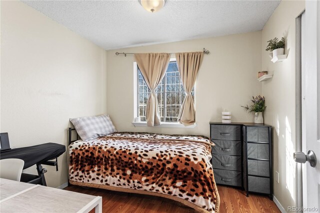 bedroom featuring hardwood / wood-style floors and a textured ceiling