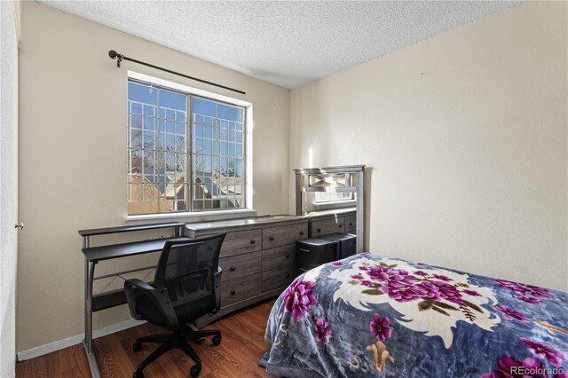 bedroom with a textured ceiling and dark hardwood / wood-style floors