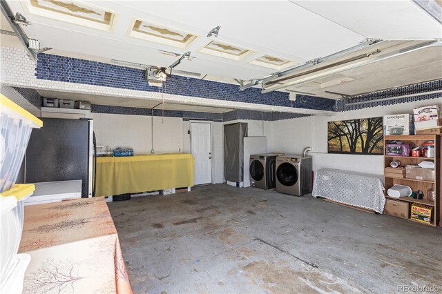 garage featuring washer and clothes dryer, a garage door opener, and fridge