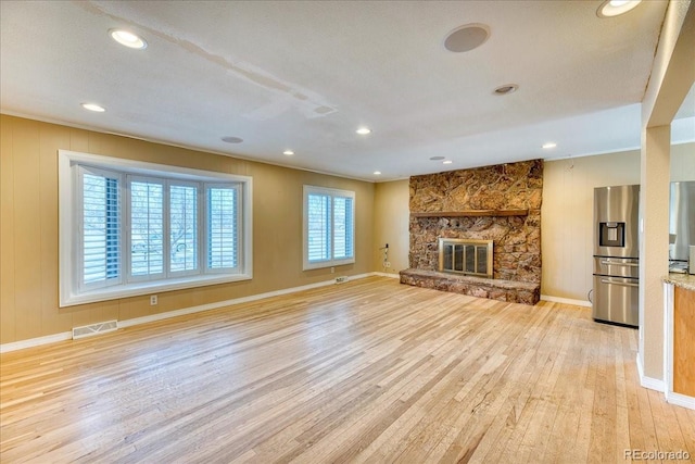 unfurnished living room with visible vents, baseboards, light wood-type flooring, recessed lighting, and a fireplace