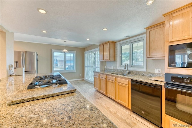 kitchen featuring a sink, light wood-type flooring, black appliances, and light brown cabinetry