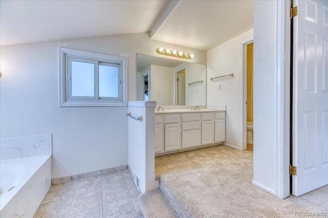 full bath with vanity, lofted ceiling, a bath, and baseboards