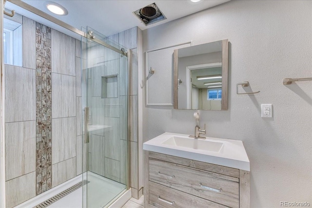 full bath with vanity and a shower stall