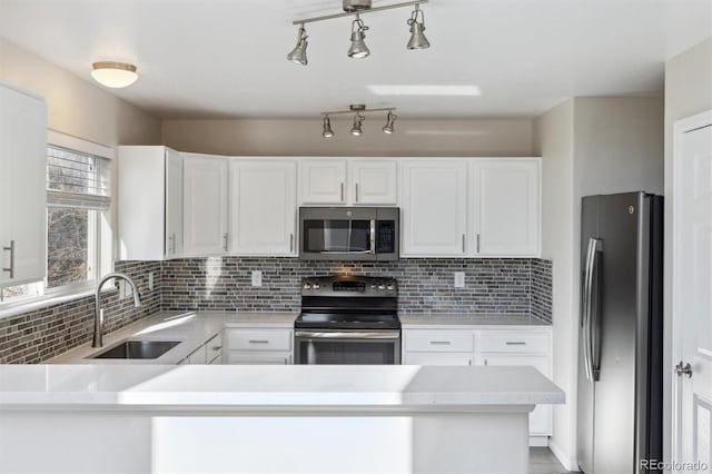 kitchen featuring stainless steel appliances, a sink, light countertops, and decorative backsplash