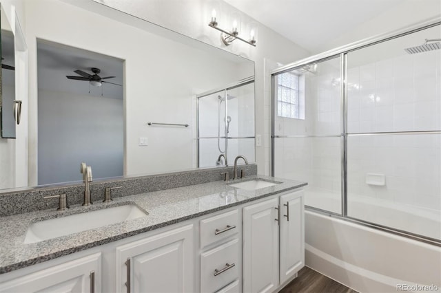 full bathroom featuring a ceiling fan, enclosed tub / shower combo, a sink, and double vanity