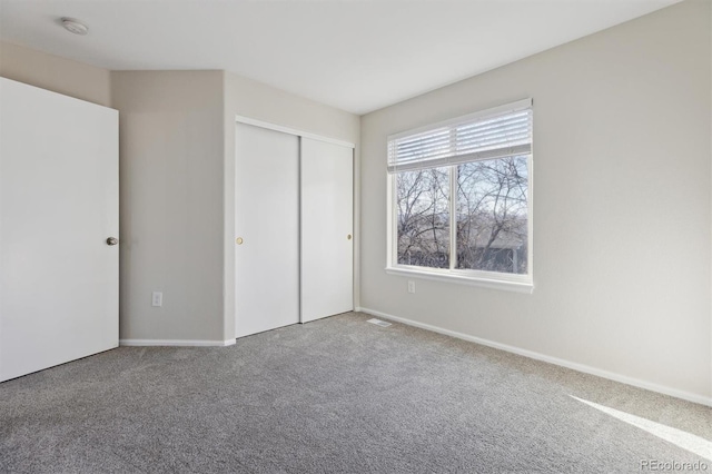 unfurnished bedroom with a closet, carpet flooring, and visible vents