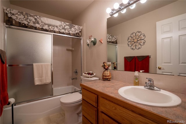 bathroom with bath / shower combo with glass door, toilet, and vanity
