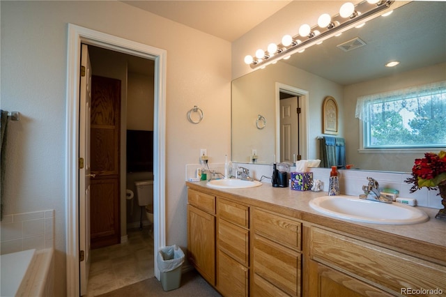 full bathroom with toilet, double vanity, and a tub to relax in