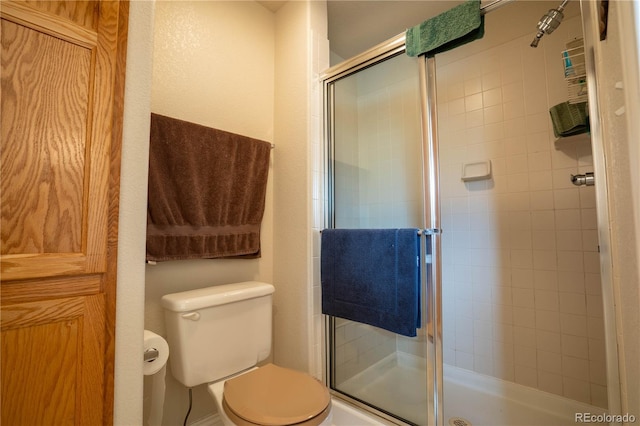 bathroom featuring a stall shower and toilet