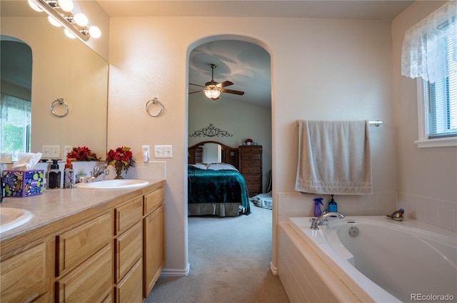 bathroom with connected bathroom, ceiling fan, a bath, and double vanity