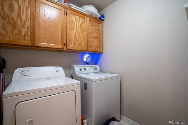 laundry room with cabinet space, washer and dryer, and baseboards