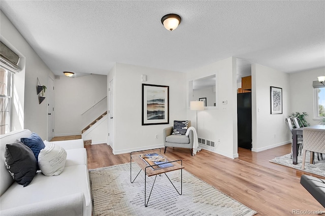 9946 Harrison St, Thornton, CO 80229 - living area with a textured ceiling, stairs, light wood-style flooring, and baseboards
