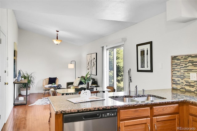 9946 Harrison St, Thornton, CO 80229 - kitchen with stainless steel dishwasher, a sink, brown cabinetry, stone countertops, and vaulted ceiling