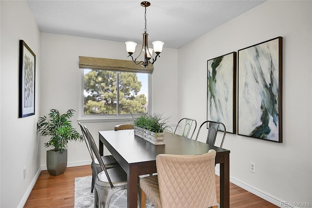 9946 Harrison St, Thornton, CO 80229 - dining room featuring a chandelier, wood finished floors, and baseboards