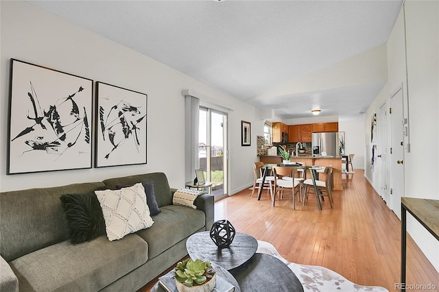 9946 Harrison St, Thornton, CO 80229 - living area with light wood-type flooring, lofted ceiling, and baseboards