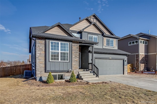 craftsman-style house featuring driveway, stone siding, fence, cooling unit, and a garage