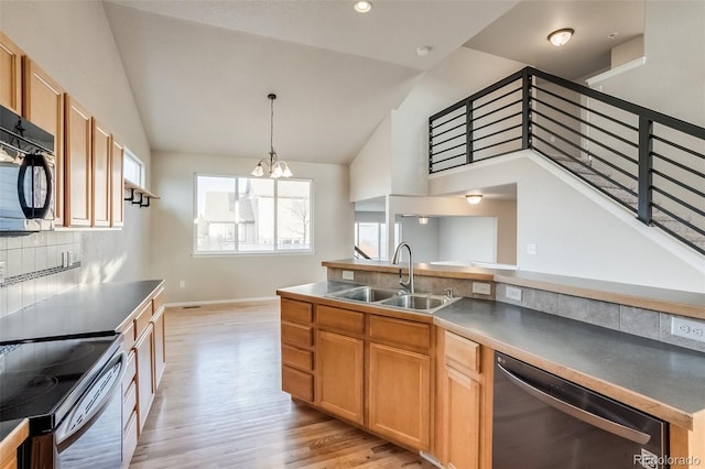 kitchen with a sink, stainless steel dishwasher, black microwave, light wood finished floors, and vaulted ceiling