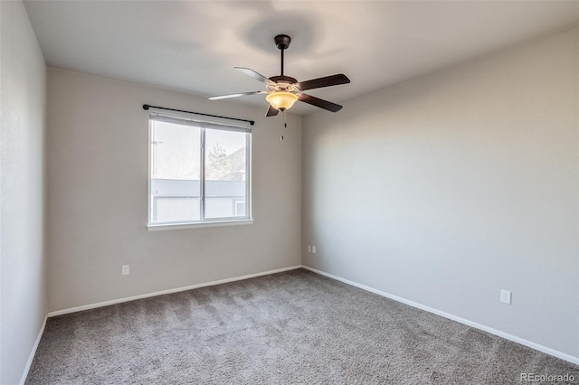 carpeted empty room featuring baseboards and a ceiling fan